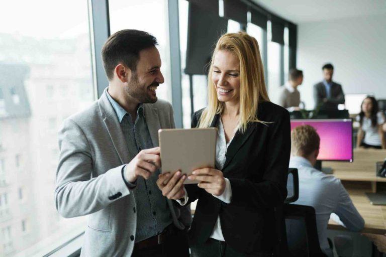 Geschäftspartner informieren sich am iPad wegen Umgründungssteuergesetz