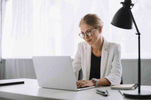 Geschäftsfrau prüft im Computer einen Unternehmenskauf