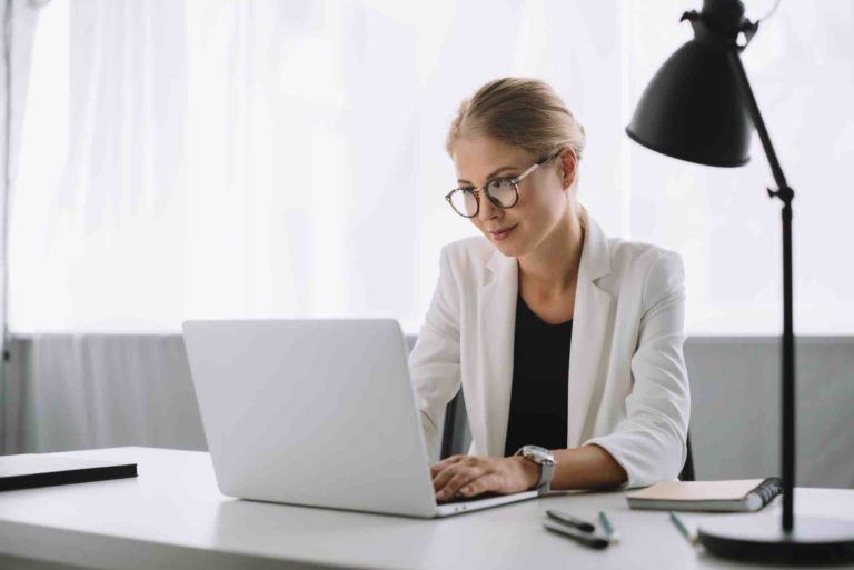 Geschäftsfrau prüft im Computer einen Unternehmenskauf