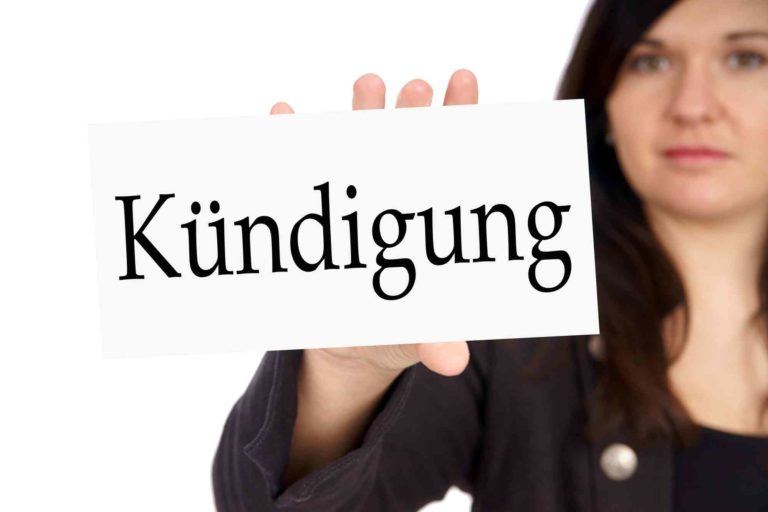 Frau hält eine Tafel in der Hand mit Kündigung