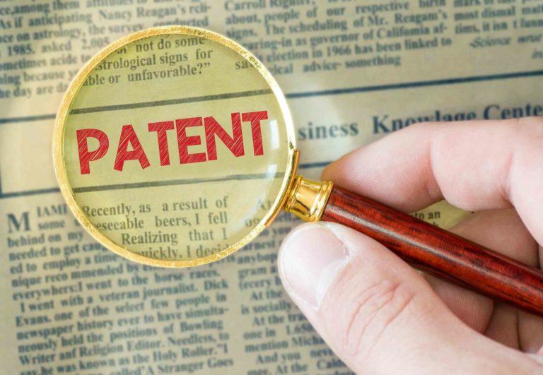 Lupe zeigt das Wort Patent in einer Zeitung