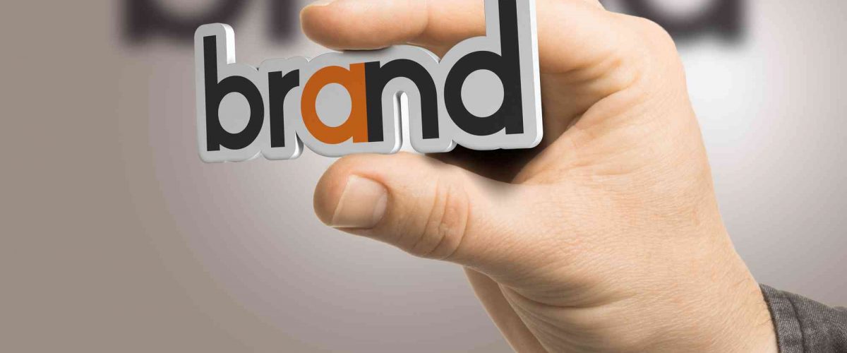 Hand hält eine Tafel mit Brand Aufschrift